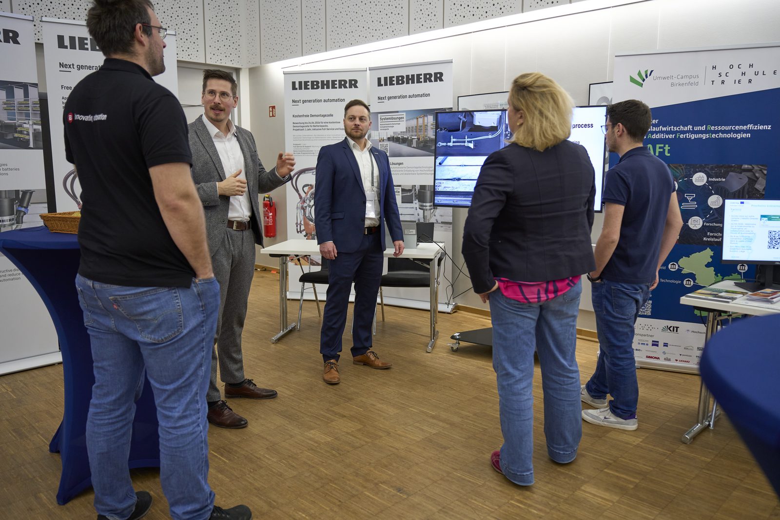 Besucher und Aussteller am Stand von Liebherr.
