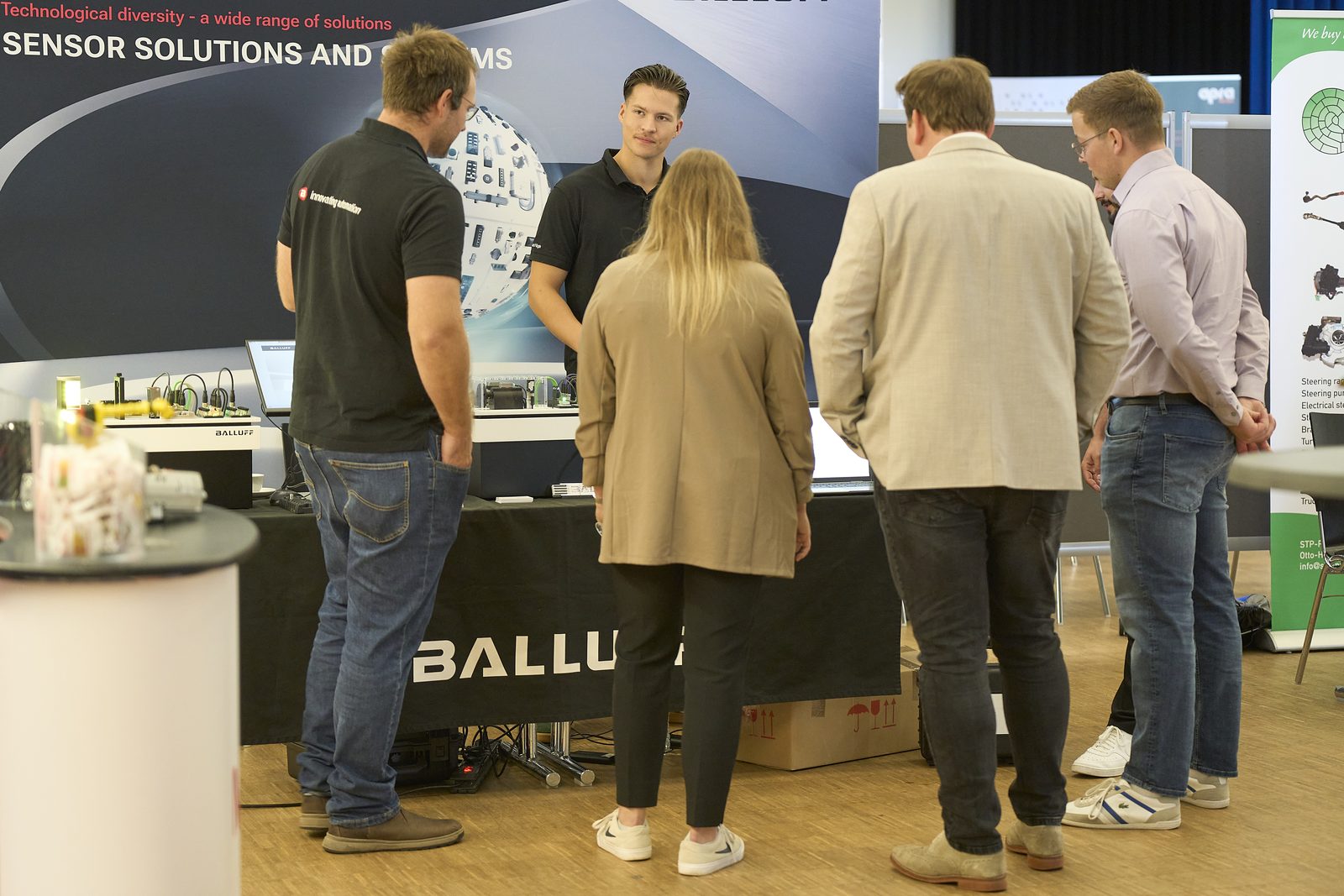 Visitors talking with exhibitors at the Balluff stand.